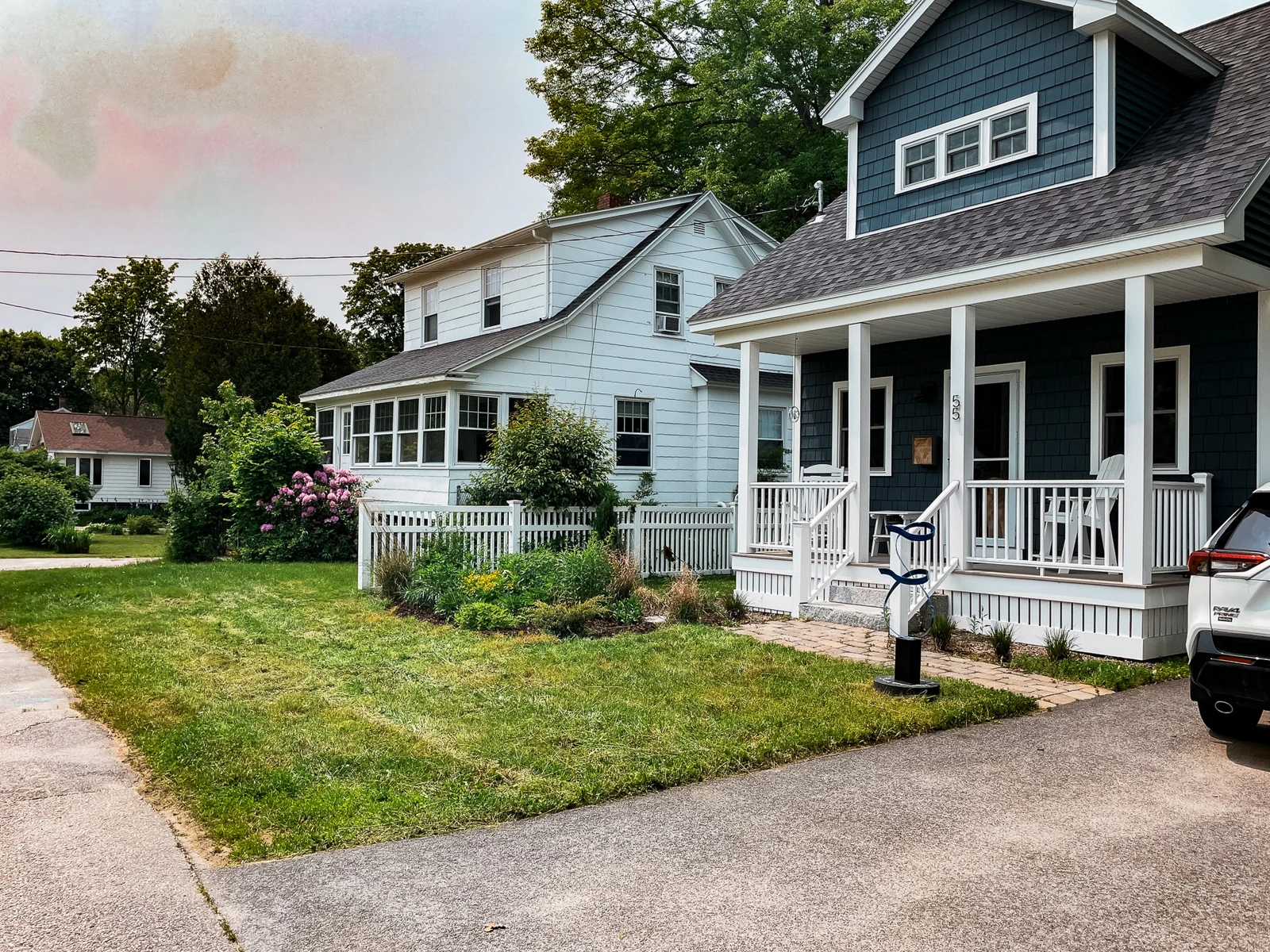 Residential Maine front lawn and planted border beside a blue house